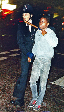 Un polica detiene a un joven en Londres durante las revueltas de 1985.
